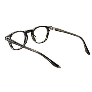 May include: A pair of eyeglasses with a dark gray, marbled pattern frame. The round lenses are clear, and the temples extend back with a slight curve. The glasses are set against a white background.