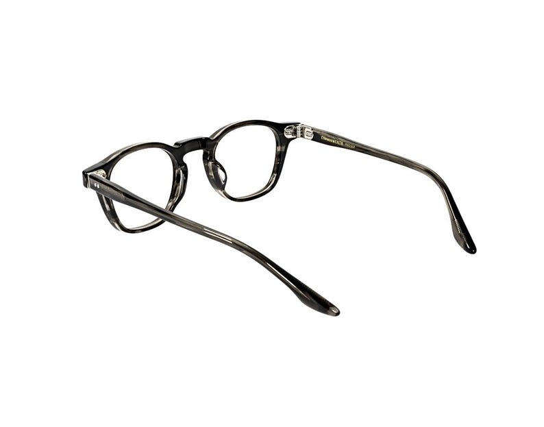 May include: A pair of eyeglasses with a dark gray, marbled pattern frame. The round lenses are clear, and the temples extend back with a slight curve. The glasses are set against a white background.