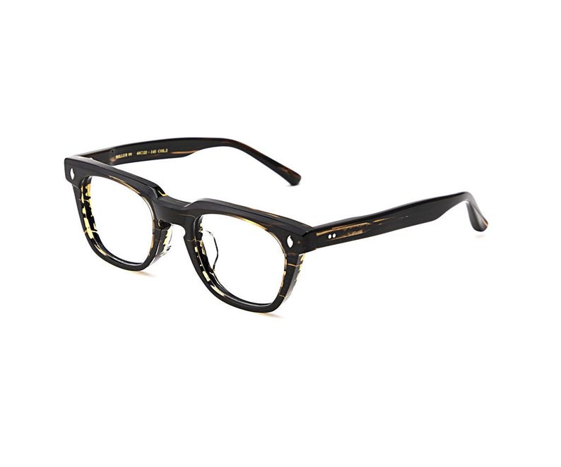 May include: Eyeglasses with a thick black frame featuring a tortoiseshell pattern on the inner rims and temples. The rectangular lenses are clear. The frame has a prominent bridge and two small silver rivets on each side of the front frame.