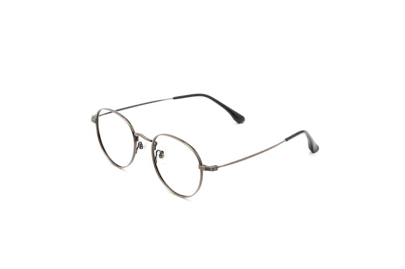 Puede incluir: Un par de gafas redondas con una montura met&aacute;lica fina y oscura. Las gafas cuentan con lentes transparentes, un puente estrecho y varillas delgadas que terminan en puntas de pl&aacute;stico negro. El dise&ntilde;o es sencillo y ligero con almohadillas.
