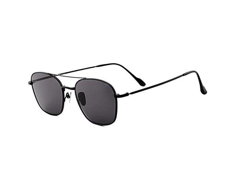May include: Black sunglasses featuring a thin metal frame with a double bridge design. The lenses are dark gray and semi-transparent, housed within rounded square rims. The temples are slender and black, extending to curved tips for a secure fit.