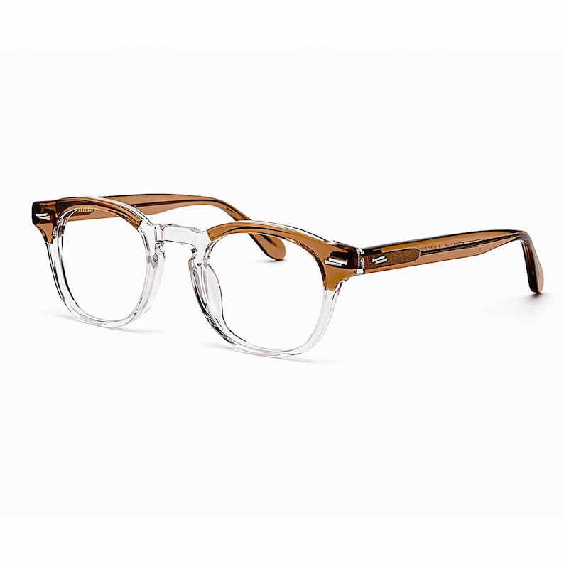 May include: Clear eyeglasses with brown temples and a square frame. The glasses have a transparent frame around the lenses and brown arms. The design is modern and stylish.