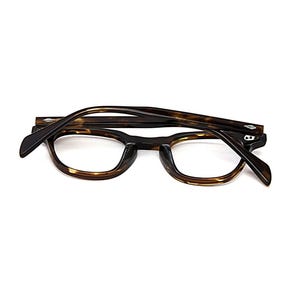 May include: Tortoiseshell eyeglasses with a dark brown and amber mottled pattern. The frames feature a rounded rectangular shape with a keyhole bridge and silver-toned diamond-shaped rivets on the front corners and temples.