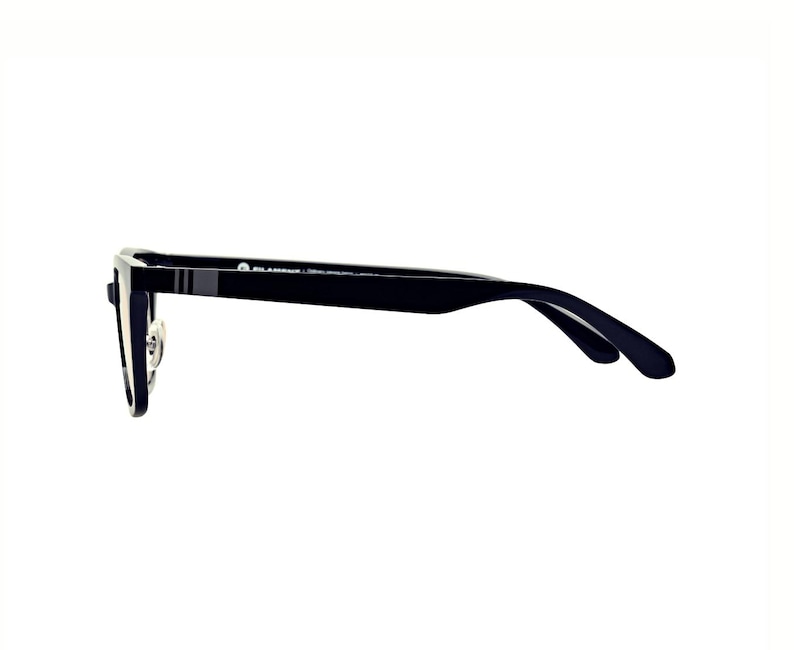May include: Black eyeglasses with a rectangular frame and a thin, dark temple. The glasses have a silver nose bridge and a small, gray stripe detail on the temple. The lenses are clear.