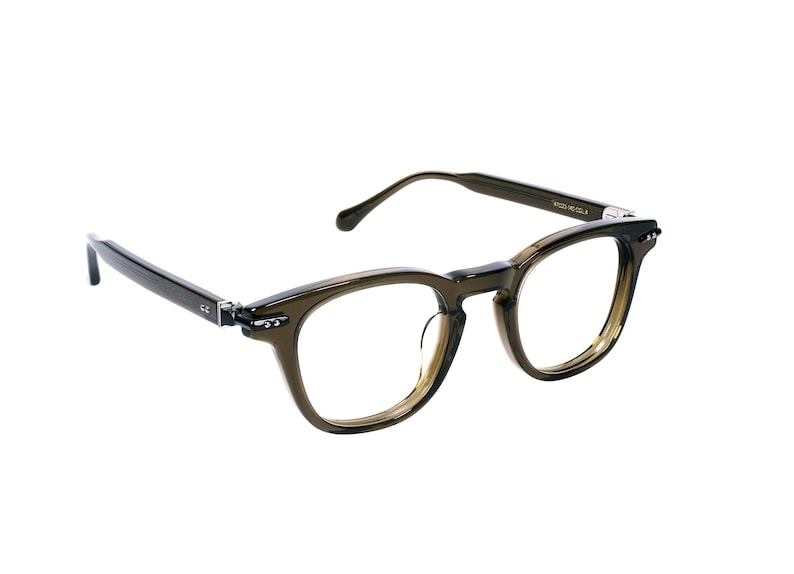 May include: A pair of olive green eyeglasses with a rounded square frame. The glasses have clear lenses and dark temples. The frame is made of a translucent material. The glasses are set against a white background.