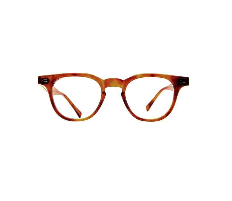 Puede incluir: Gafas con estampado de carey. Las monturas son de color marr&oacute;n c&aacute;lido, con forma redondeada. Las lentes son transparentes y las patillas son delgadas e inclinadas.