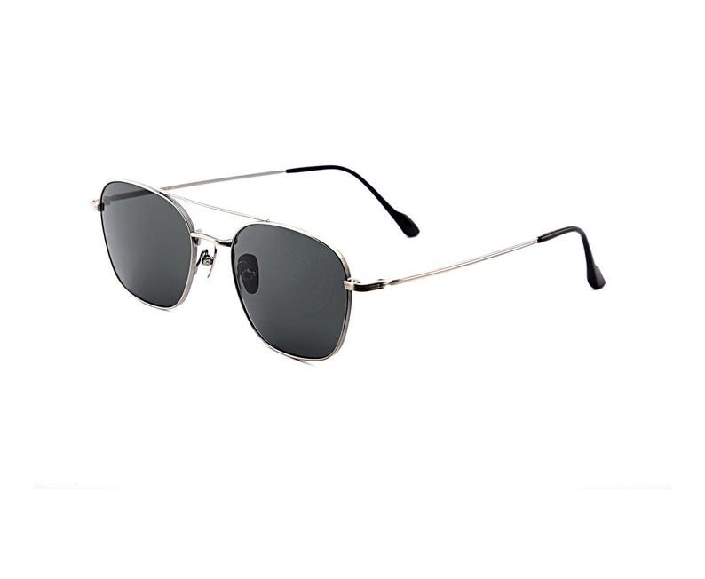 May include: Silver-toned metal frame sunglasses featuring a double bridge design and dark gray tinted lenses. The thin temples are finished with black plastic tips, providing a sleek and functional look for these classic aviator-style eyewear.