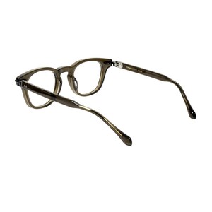 May include: A pair of eyeglasses with a dark, translucent frame. The glasses have a classic, rounded shape and are angled slightly, showcasing the temples and hinges. The lenses are clear, and the overall design is modern and minimalist.
