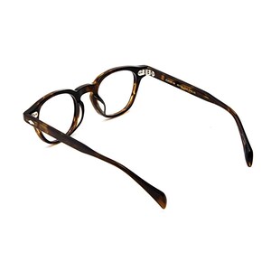 May include: Tortoiseshell-patterned eyeglasses with a rounded frame shape. The inner temple arm features gold-toned text that reads "POKER 46" followed by "MADE IN ITALY". The glasses have clear lenses and a glossy finish on the acetate material.