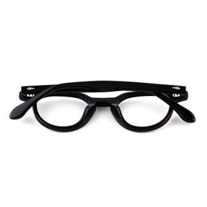 May include: Black, round-framed eyeglasses with a keyhole bridge. The glasses have a classic design with thick, glossy black frames and clear lenses. The arms are also black and extend to the temples.