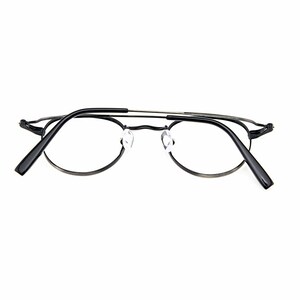 May include: A pair of eyeglasses featuring a thin, dark metallic frame with a double bridge design. The glasses have clear lenses, adjustable transparent nose pads, and black temple tips. The frame has a rounded shape with a sleek, minimalist construction that highlights the structural details of the bridge and the hinges connecting the temples to the front of the eyewear.