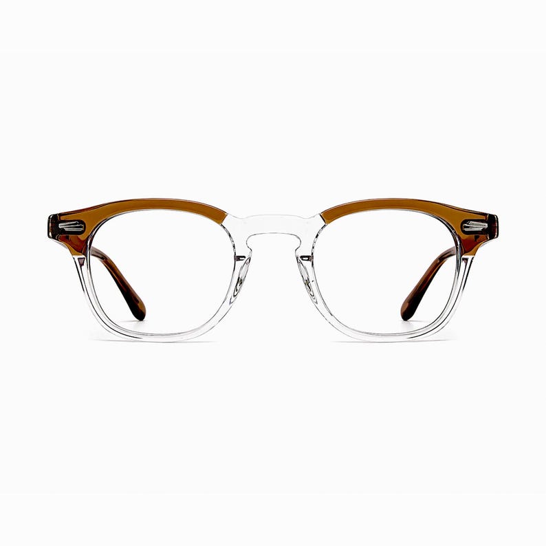 May include: Clear eyeglasses with a brown upper frame and temples. The glasses have a classic, round shape and are set against a white background. The lenses are clear, and the frame is a combination of clear and brown plastic.