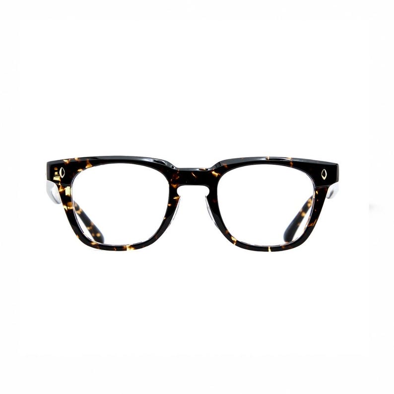 Puede incluir: Gafas con un patr&oacute;n de carey cl&aacute;sico. Las monturas son una mezcla de negro y marr&oacute;n, con forma cuadrada y lentes transparentes. Peque&ntilde;os detalles plateados son visibles en las patillas.