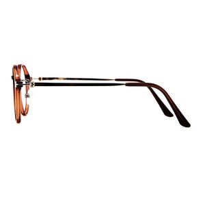 May include: A pair of eyeglasses with translucent amber-colored round frames and thin metallic silver-toned bridge and temple arms. The temple tips are finished in a dark brown material, providing a contrast to the lighter frame front.
