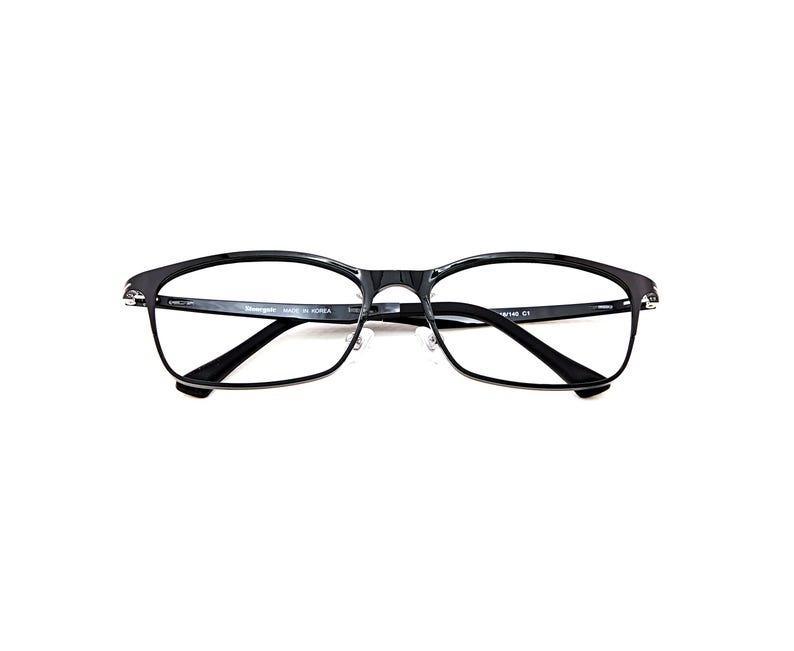 Puede incluir: Gafas rectangulares negras con puente y bisagras plateadas. Las gafas tienen un dise&ntilde;o elegante y moderno con un acabado brillante. Las lentes son transparentes y las monturas son de un material duradero.