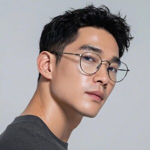 May include: Thin-rimmed, round-shaped eyeglasses with a dark metallic frame. The glasses feature a minimalist bridge design and slender temples, providing a lightweight appearance. The lenses are clear, showcasing a classic and functional eyewear style.