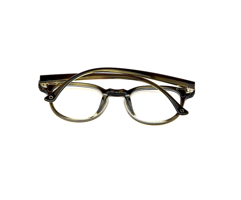 May include: Tortoiseshell-patterned eyeglasses with a rounded frame shape and clear lenses. The frame features a dark brown and amber mottled design with a glossy finish, thin temples, and a bridge connecting the two circular lens rims.