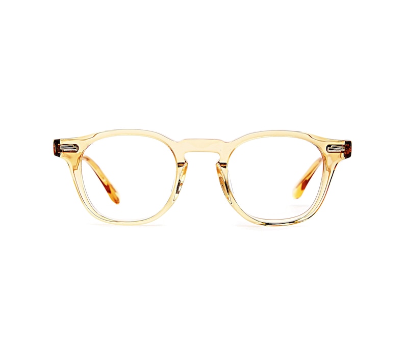 Puede incluir: Un par de gafas con montura redonda transparente, con un tinte &aacute;mbar claro. Las monturas tienen una calidad sutil y transl&uacute;cida, y las patillas son de un color &aacute;mbar m&aacute;s oscuro. Las gafas est&aacute;n dise&ntilde;adas con un estilo cl&aacute;sico y unisex.