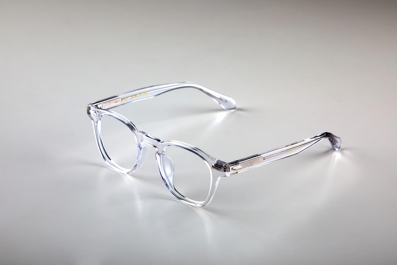 K&ouml;nnte beinhalten: Klare Brille mit quadratischem Rahmen und transparentem Design. Die Brille hat eine klassische Form mit einer dezenten, modernen &Auml;sthetik. Rahmen und B&uuml;gel bestehen aus transparentem Material.