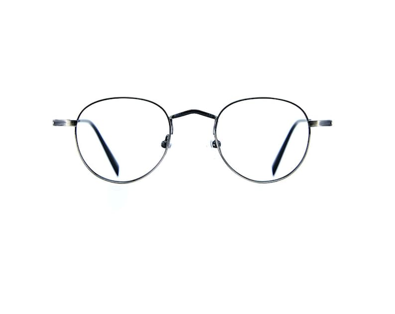 May include: Round eyeglasses featuring a thin, dark metallic frame with a bridge connecting the two circular lenses. The temples extend horizontally from the sides of the frame, showcasing a simple, functional design with clear lenses.