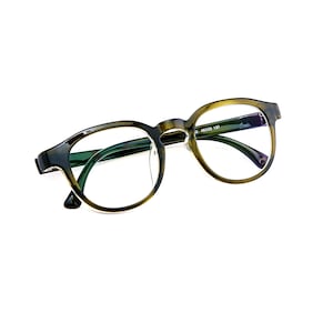 May include: Tortoiseshell-patterned eyeglasses with round frames and clear lenses. The inner temple arm features the printed text 46 23 137. These glasses have a classic bridge design and thin, curved arms, providing a clear view of the frame structure.