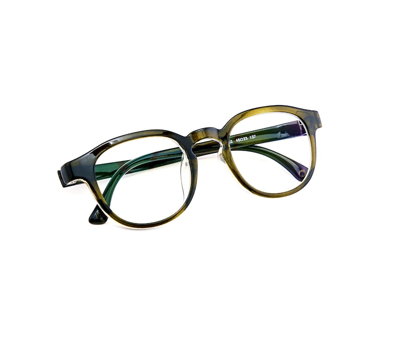 May include: Tortoiseshell-patterned eyeglasses with round frames and clear lenses. The inner temple arm features the printed text 46 23 137. These glasses have a classic bridge design and thin, curved arms, providing a clear view of the frame structure.