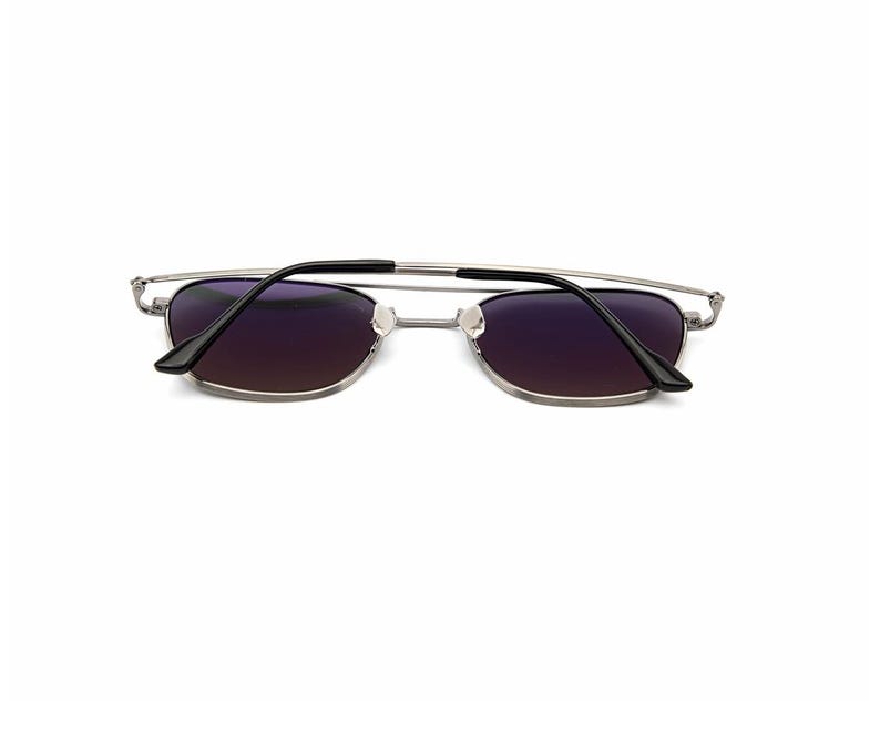 May include: Silver-toned metal frame sunglasses featuring rectangular lenses with a dark purple gradient tint. The thin wire frame includes a double bridge design and black plastic temple tips, showcasing a sleek and functional eyewear construction.