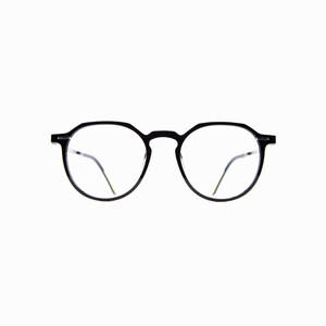 May include: Black-framed eyeglasses with a round shape. The glasses have clear lenses and thin, silver-colored arms. The frame is made of a matte black material. The overall design is minimalist and modern.