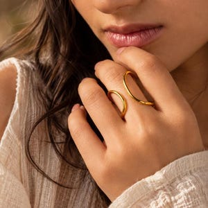 Sculpturale goudkleurige wikkelring, verstelbare open band, moderne minimalistische sieraden