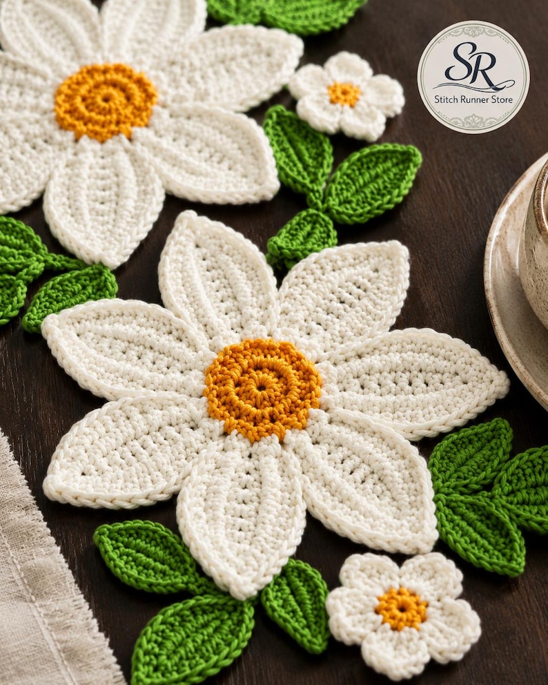 K&ouml;nnte beinhalten: Geh&auml;kelte Untersetzer und Dekorationen in G&auml;nsebl&uuml;mchenform in Wei&szlig; mit gelben Mitten und gr&uuml;nen Bl&auml;ttern. Das Set enth&auml;lt gro&szlig;e und kleine Blumenmotive. Ein kreisf&ouml;rmiges Logo in der oberen rechten Ecke zeigt den Text Stitch Runner Store.