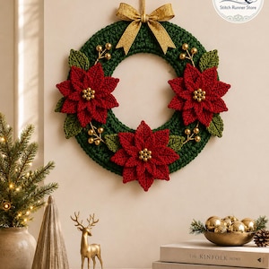 May include: A circular crochet wreath in dark green featuring three red poinsettia flowers with gold bead centers, green crocheted leaves, and gold berry accents. A gold ribbon bow is attached to the top, and the Stitch Runner Store logo is visible.