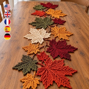 May include: A crochet table runner featuring a series of interconnected maple leaves in shades of red, orange, yellow, cream, and olive green. The leaves are arranged in a vine-like pattern, showcasing detailed stitch textures throughout the design.