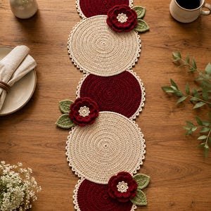 Puede incluir: Camino de mesa de ganchillo hecho a mano con manteles individuales circulares burdeos y crema alternados. Cada mantel individual burdeos tiene un borde festoneado crema. Se adjuntan aplicaciones de flores rojas con hojas verdes.