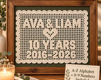 May include: A rectangular cream-colored crochet piece framed in dark wood, featuring the text "AVA & LIAM", a heart symbol, "10 YEARS", and "2016-2026". A small sign nearby reads "A-Z Alphabet + 0-9 Numbers Included" with decorative leaf graphics.