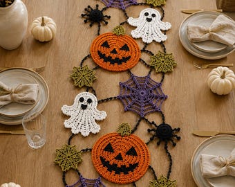 May include: A Halloween-themed crochet table runner featuring orange pumpkins with black faces, white ghosts, purple spiderwebs, green star-shaped motifs, and black spiders connected by a black crocheted chain, arranged in a decorative garland pattern.