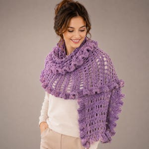 May include: A light purple, crocheted shawl with a ruffled edge. The shawl is draped over the shoulders and has an open, lacy design. The color is a soft, muted lavender.