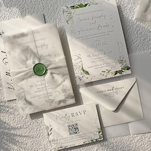 Puede incluir: Elegante juego de invitaciones de boda con una invitación principal, una tarjeta de confirmación de asistencia y un sobre. La invitación incluye los nombres Carrie Murphy y Ariana Broks, la fecha, la hora y el lugar. El conjunto está atado con una cinta blanca y sellado con un sello de cera verde.