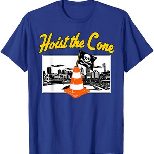 May include: Blue t-shirt with a graphic featuring a pirate flag atop an orange traffic cone, set against a cityscape. The text "Hoist the Cone" is in yellow above the graphic.