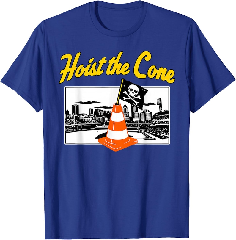 May include: Blue t-shirt with a graphic featuring a pirate flag atop an orange traffic cone, set against a cityscape. The text "Hoist the Cone" is in yellow above the graphic.