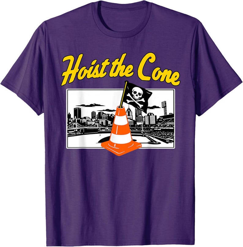May include: Purple t-shirt with the text "Hoist the Cone" in yellow. The graphic features a black and white cityscape with a pirate flag and an orange traffic cone.