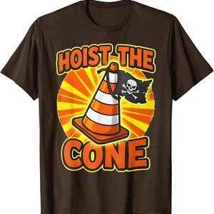Pu&ograve; includere: T-shirt marrone con grafica di un cono arancione e bianco con bandiera pirata. Il testo "HOIST THE CONE" e "CONE" &egrave; arancione, bordato di giallo.