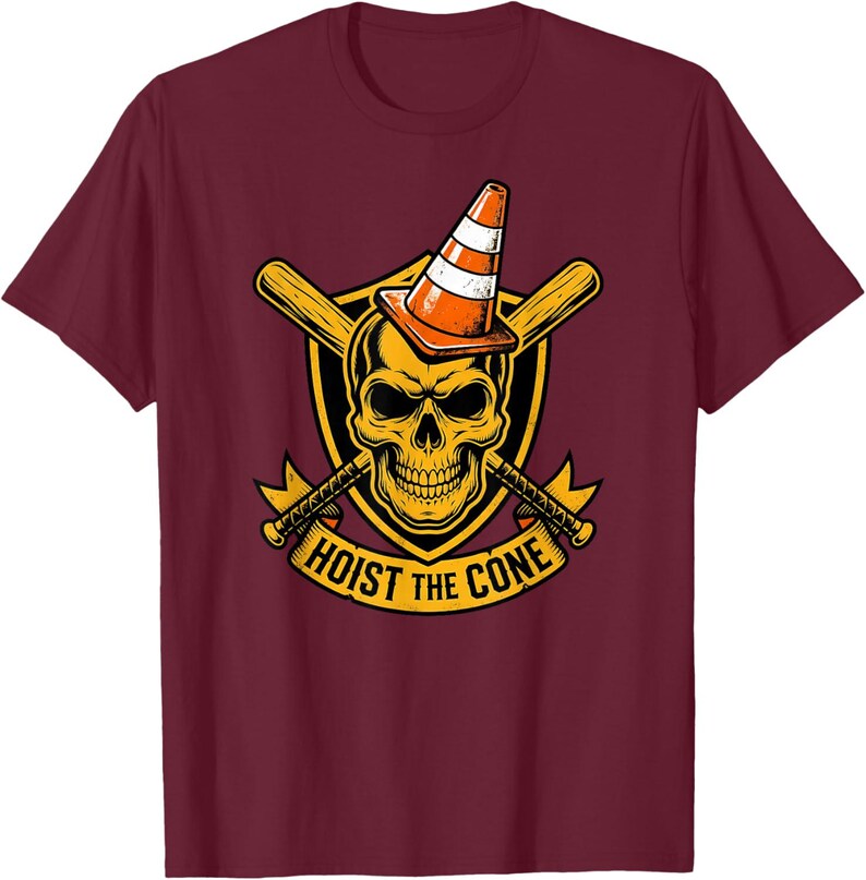 May include: Maroon t-shirt featuring a graphic of a skull wearing an orange and white traffic cone. The skull is set against a yellow shield with crossed baseball bats and the text "HOIST THE CONE".