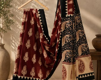 May include: A long fabric drape featuring a deep maroon section with a repeating cream paisley print and a black border with a white triangular pattern. The adjacent section displays a black background with intricate cream and maroon paisley motifs.