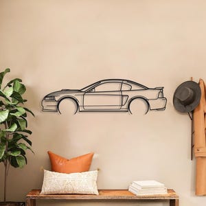 May include: A black metal car outline wall art piece. The artwork is mounted on a beige wall above a wooden bench with cushions and baskets. A plant in a black pot is to the left. The car is a coupe.