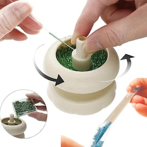 May include: A cream-colored bead spinner tool with a central spindle, shown in use with a needle picking up green beads. The device features a rotating bowl design to facilitate stringing small beads, with additional views showing bead loading.