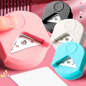 May include: A collection of corner rounder paper cutters in pink, black, white, and blue. Each cutter has a triangular blade and a circular top. A hand holds the pink cutter, and a white card is being cut.