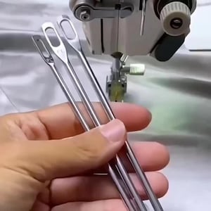May include: Three silver-colored metal loop turners with elongated, oval-shaped eyes at the top ends. Each tool features a smooth, slender shaft and a rounded tip, designed for turning fabric tubes. The metal surfaces are reflective and polished.