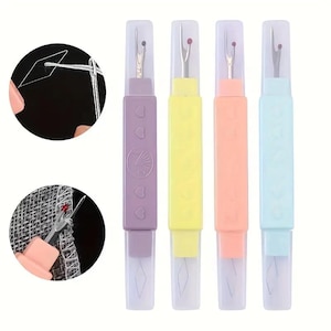 May include: Four seam rippers in pastel colors: purple, yellow, peach, and blue. Each has a clear plastic cap and a metal blade with a red tip. The purple ripper has heart and floral designs.