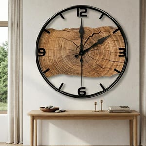May include: A circular wall clock with a black metal frame and a natural wood slice centre. The clock face has black numerals at the 12, 3, 6, and 9 o'clock positions, with black hands. The wood slice shows visible growth rings.