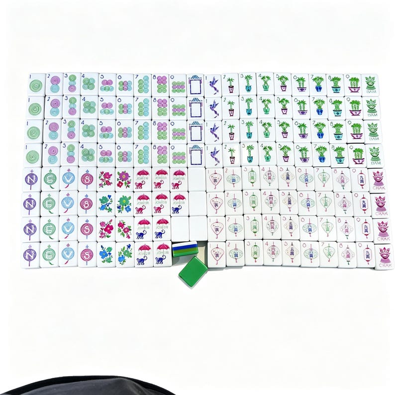 May include: A complete set of white rectangular mahjong tiles arranged in a grid. The tiles feature colorful illustrations of flowers, birds, monkeys, lanterns, bamboo, and numerical characters. Two loose green and blue tiles are placed below the grid.